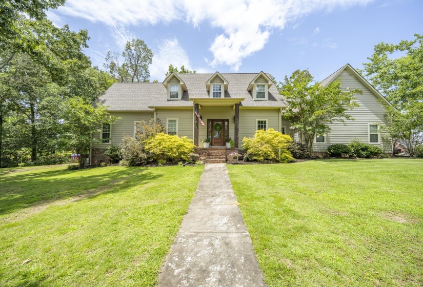 Traditional-style home featuring light green siding, a gabled roof, and three dormer windows