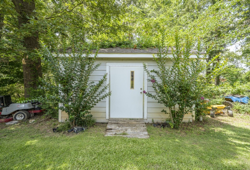 Utility shed with horizontal siding and a white entry door