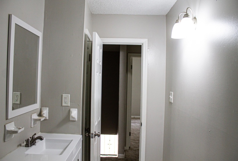 Bathroom vanity with a rectangular sink, wall-mounted mirror, and brushed chrome faucet