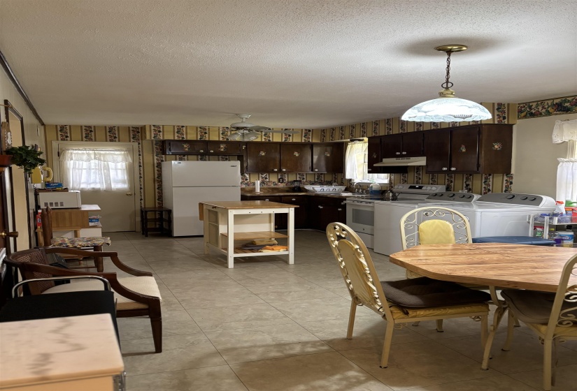 Dining space featuring a textured ceiling, plenty of natural light, a ceiling fan, separate washer and dryer, and wallpapered walls