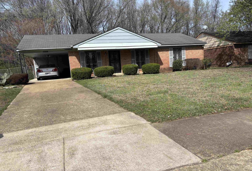 Single story home with a carport, driveway, a front lawn, and a porch