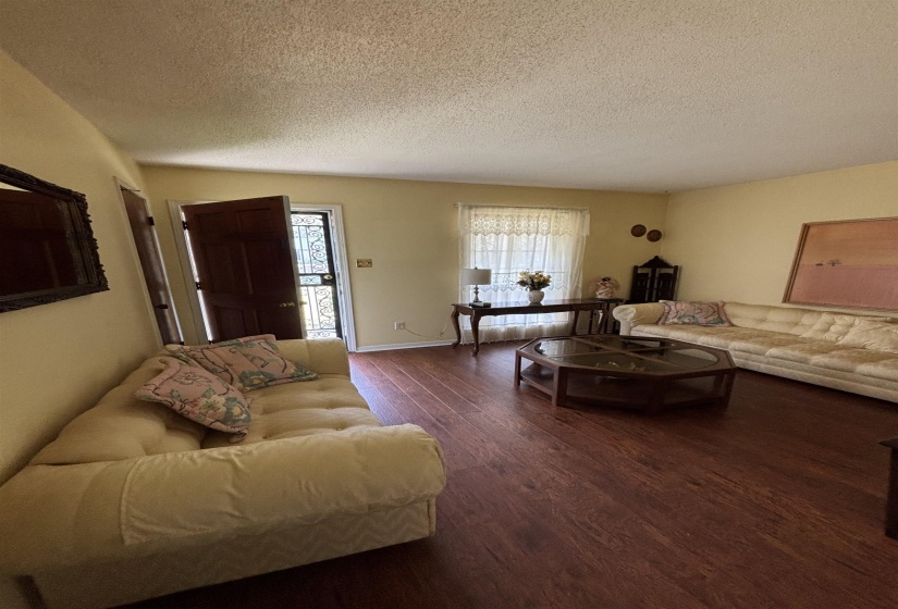 Living room with dark wood finished floors and a textured ceiling