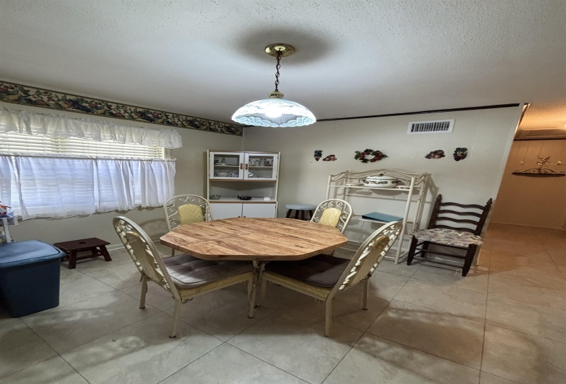 Dining space with a textured ceiling and light tile patterned floors
