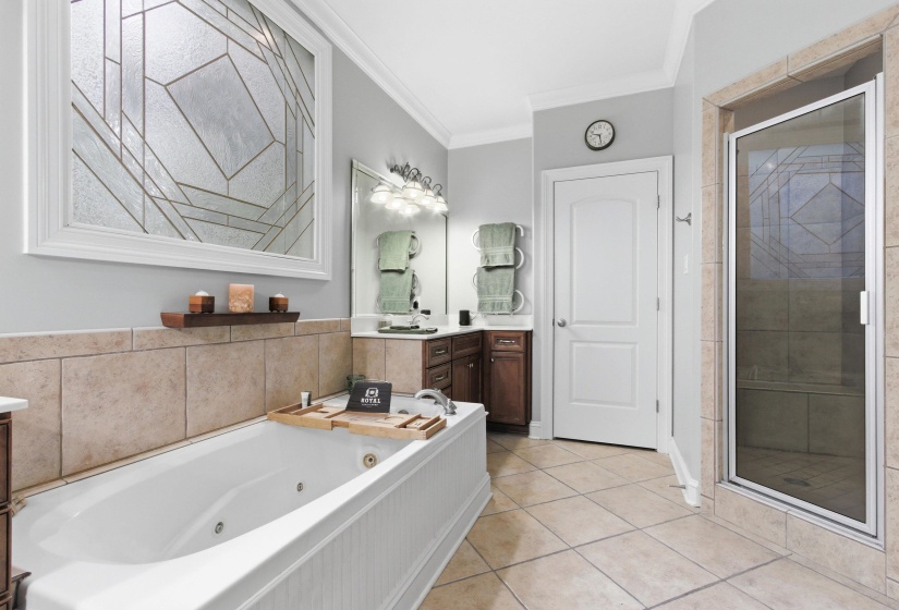 Jetted soaking tub with beadboard paneling, surrounded by large format wall tile