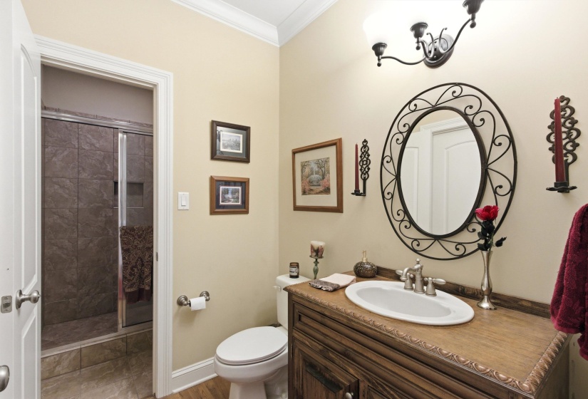 Wood-finish vanity with an oval undermount sink and a decorative iron-framed mirror