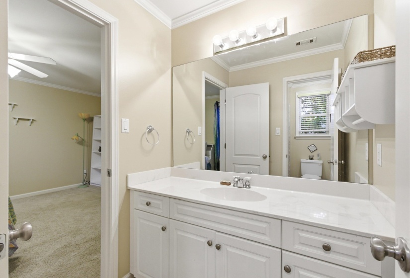 Bathroom vanity featuring a white countertop, integrated sink, and white cabinetry with brushed nickel hardware