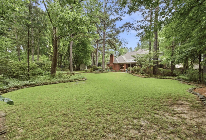 Expansive green lawn surrounded by mature trees