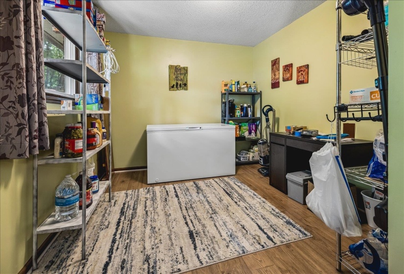 Room featuring wood-finish flooring, a window with natural light, and light-colored walls