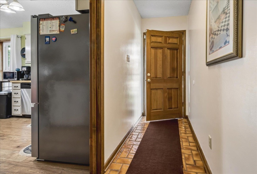 Entryway featuring a paneled wood door and terracotta-style tile flooring
