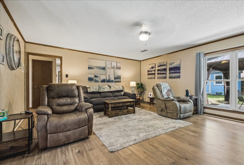 Spacious living area featuring wood-finish flooring, neutral wall tones, and recessed lighting