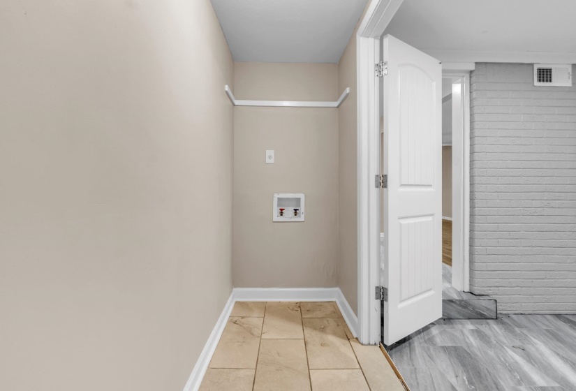 Dedicated utility area featuring tile flooring, neutral wall tones, and white trim
