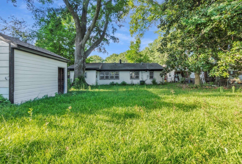 Spacious rear yard with a detached storage shed and mature trees