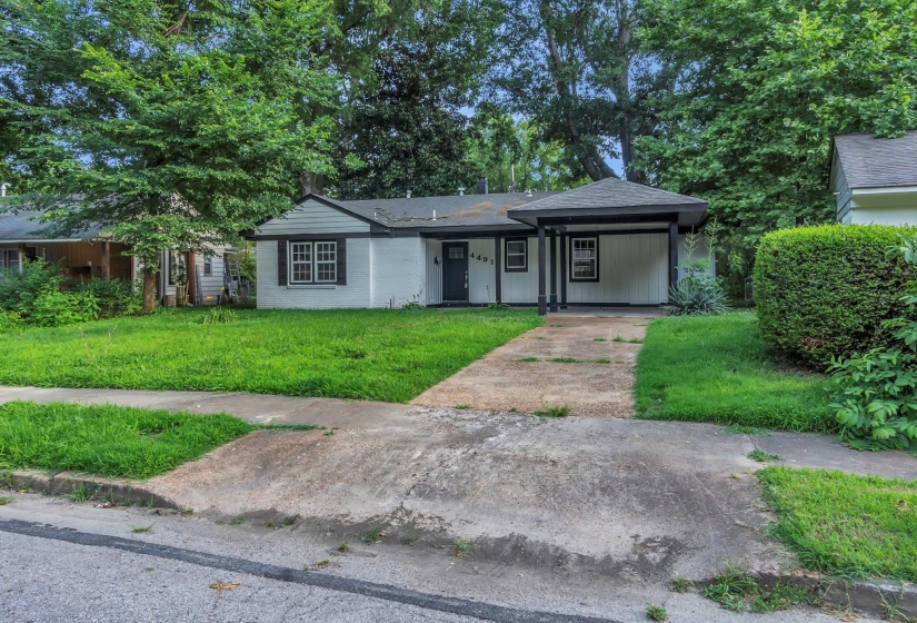 Ranch-style residence featuring a covered front entry, dark trim accents, and a concrete driveway