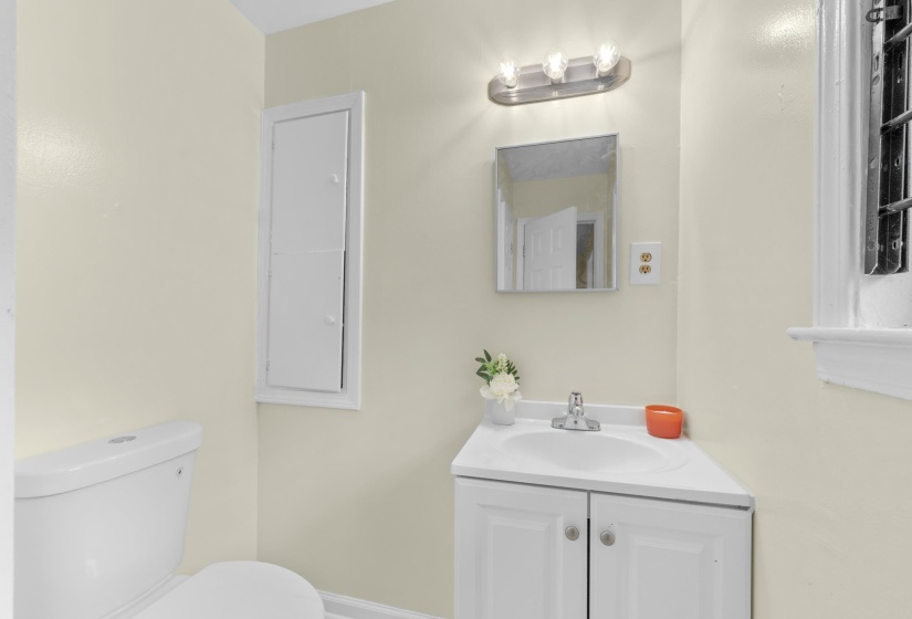 Bathroom featuring a white toilet, corner vanity with cabinet storage, and a mirrored medicine cabinet