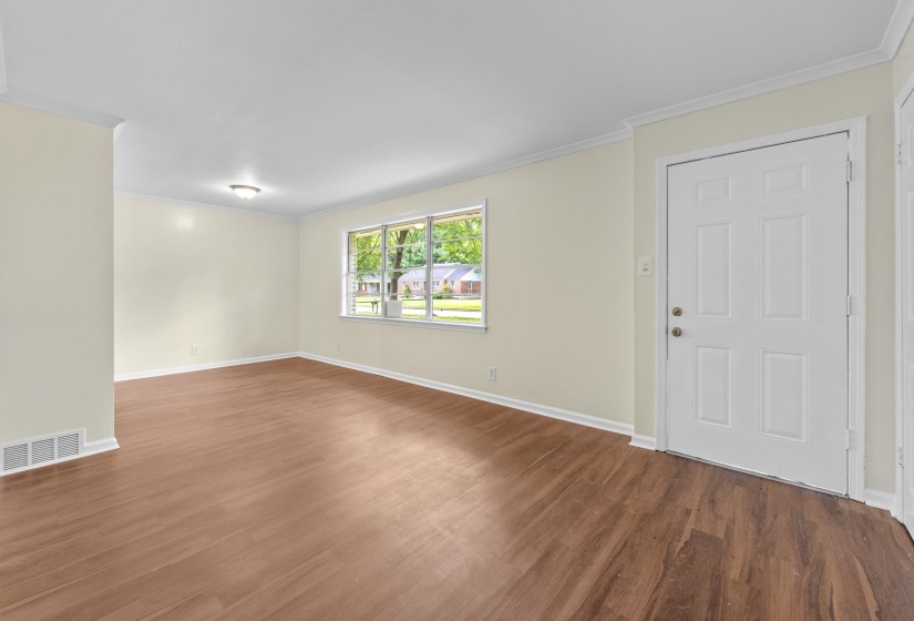 Entryway featuring wood-finish flooring, a white paneled door, and crown molding