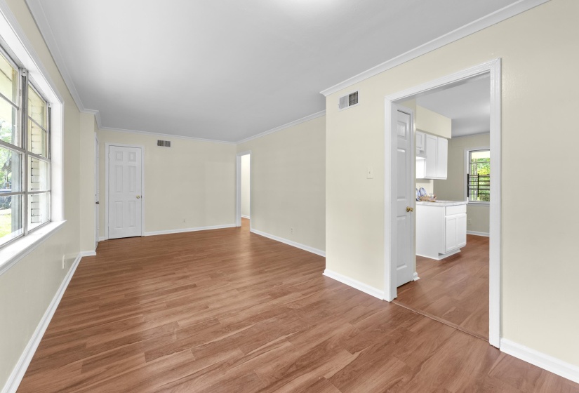 Spacious interior featuring wood-finish flooring, light-toned walls, and white crown molding