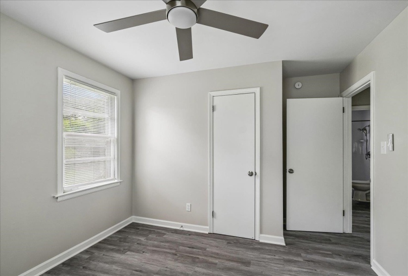 Room featuring wood-finish flooring, a contemporary ceiling fan, and light gray wall tones