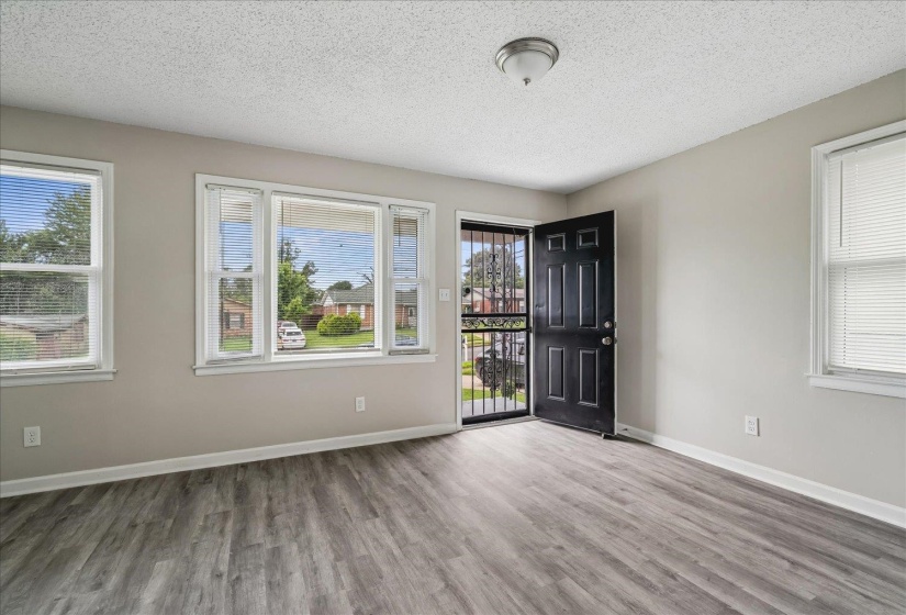 Open concept room featuring wood-finish flooring, light neutral wall tones, and white trim