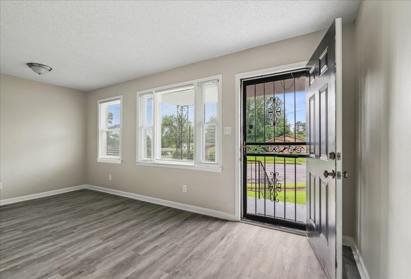 Entryway with wood-finish flooring, light neutral wall paint, and white trim
