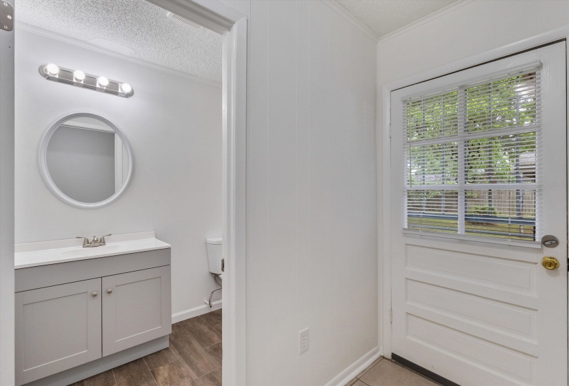 Bathroom entry featuring a white paneled door with a privacy glass inset
