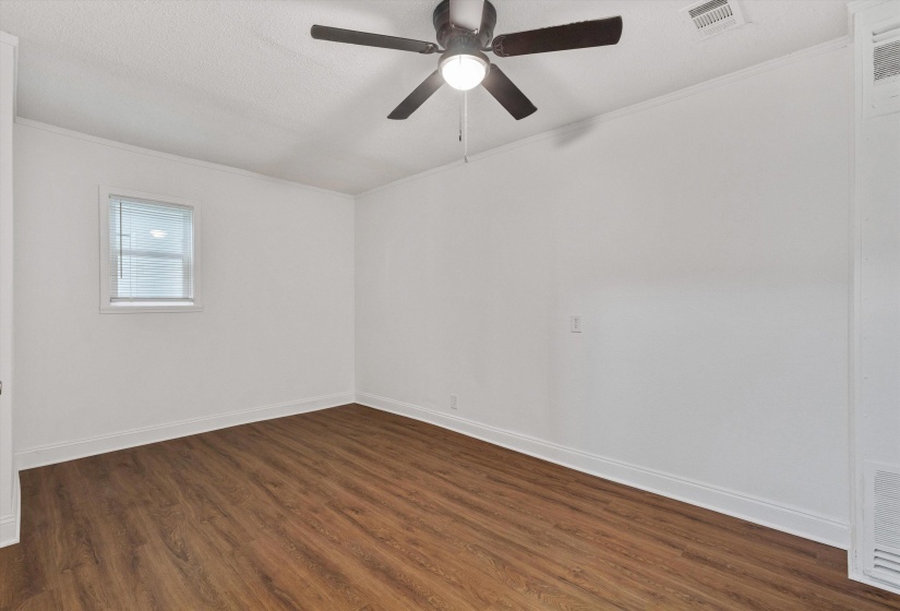 Room featuring wood-finish flooring, white walls, a ceiling fan with integrated lighting, a window with horizontal blinds, and white baseboards