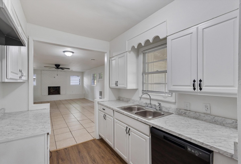 Kitchen featuring white cabinetry, stone-finish countertops, and a double-basin stainless steel sink