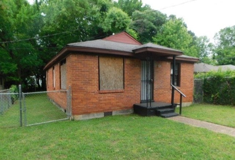 Brick exterior with a covered entryway and concrete steps