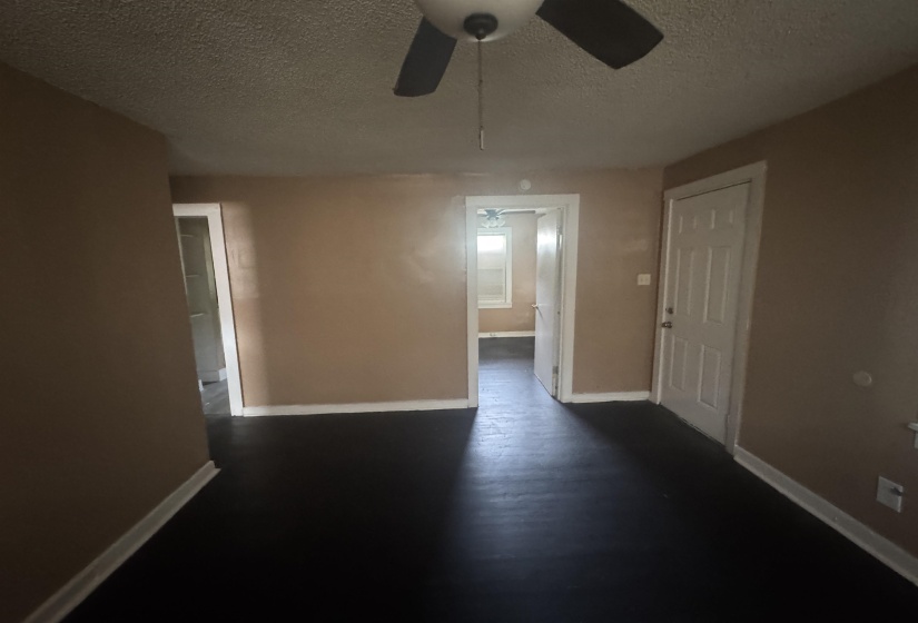 Interior room featuring dark flooring, neutral wall paint, and white trim