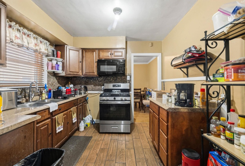 Kitchen featuring wood-finish flooring, recessed lighting, and a stainless steel range with overhead microwave