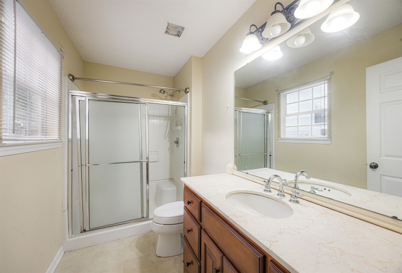 Bathroom featuring vanity, a stall shower, and light tile patterned flooring