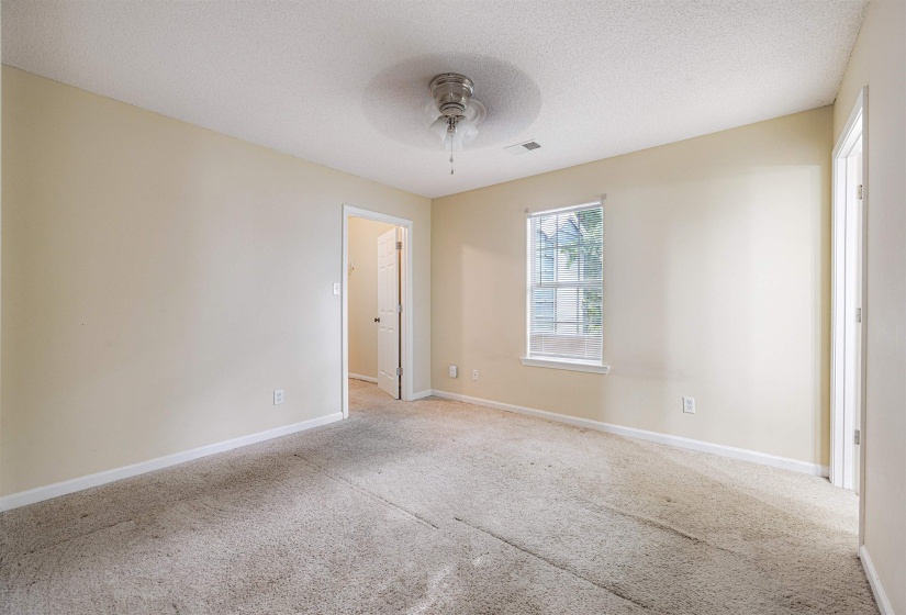 Carpeted empty room with a textured ceiling and a ceiling fan