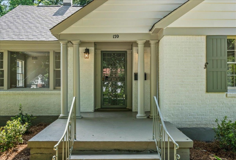 Covered front entry featuring a screen door, decorative columns, and a fixed exterior light fixture