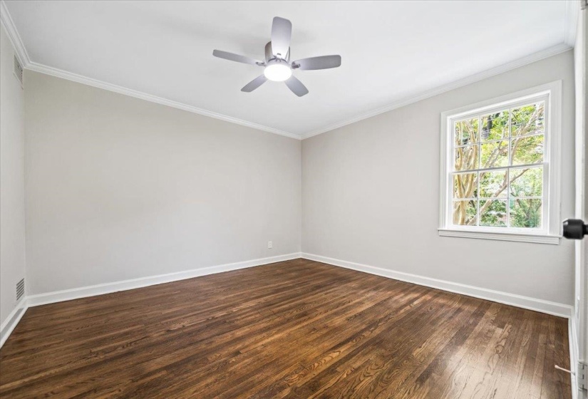 Hardwood flooring, crown molding, and a ceiling fan with integrated lighting