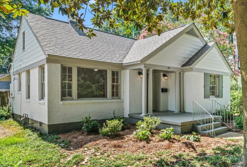 White brick exterior featuring a covered porch with architectural columns