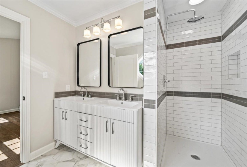 Bathroom featuring a dual vanity with white cabinetry, square vessel sinks, and modern black-framed mirrors