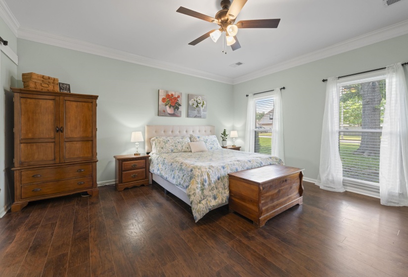 Spacious room featuring wood-finish flooring, light-toned walls, and a ceiling fan with integrated lighting