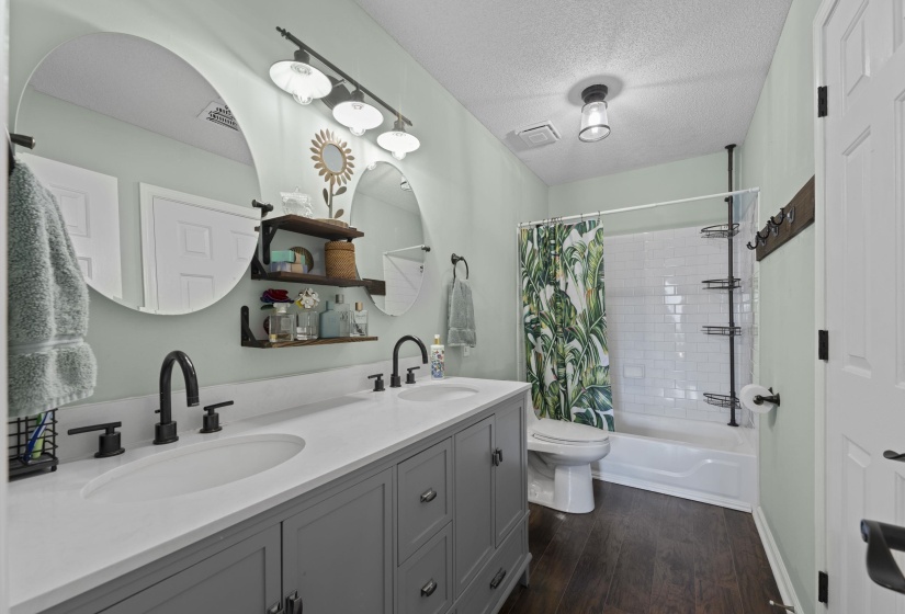 Bathroom featuring a dual vanity with a light-colored countertop and integrated sinks