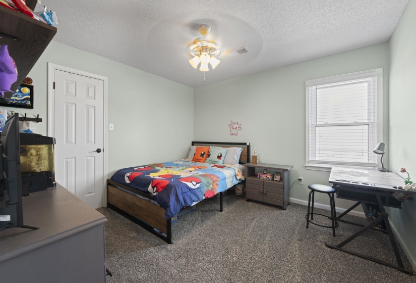 Carpeted room with a ceiling fan, a window with blinds, and a white paneled door