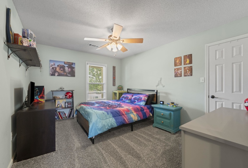 Carpeted room featuring a ceiling fan with integrated lighting, a window with blinds, and a paneled interior door