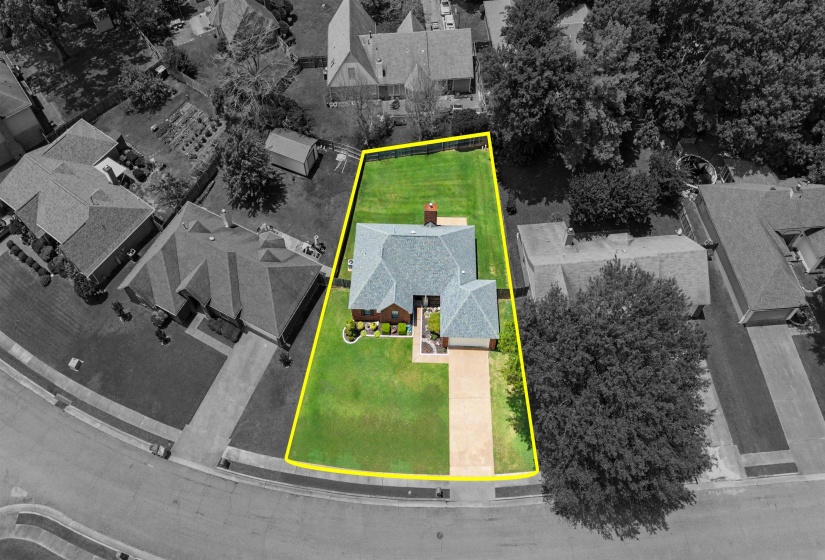 Expansive green lawn surrounds a single-story residence with a light-colored shingle roof