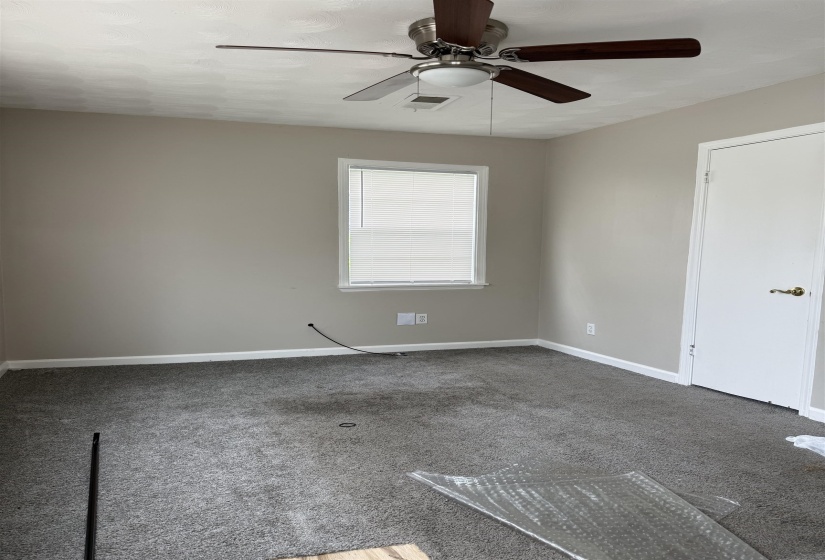 Room featuring light-toned walls, a window with blinds, and a ceiling fan with integrated lighting