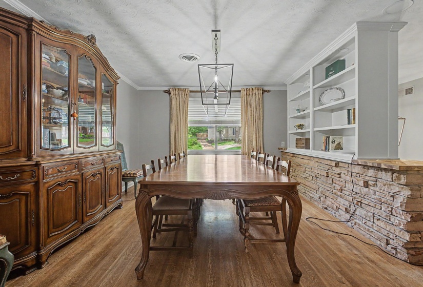 Wood-finish flooring throughout, complemented by a stone-faced partial wall with built-in shelving
