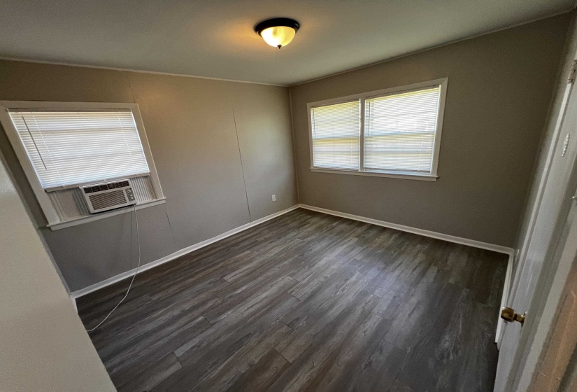 Spare room featuring dark wood-style flooring