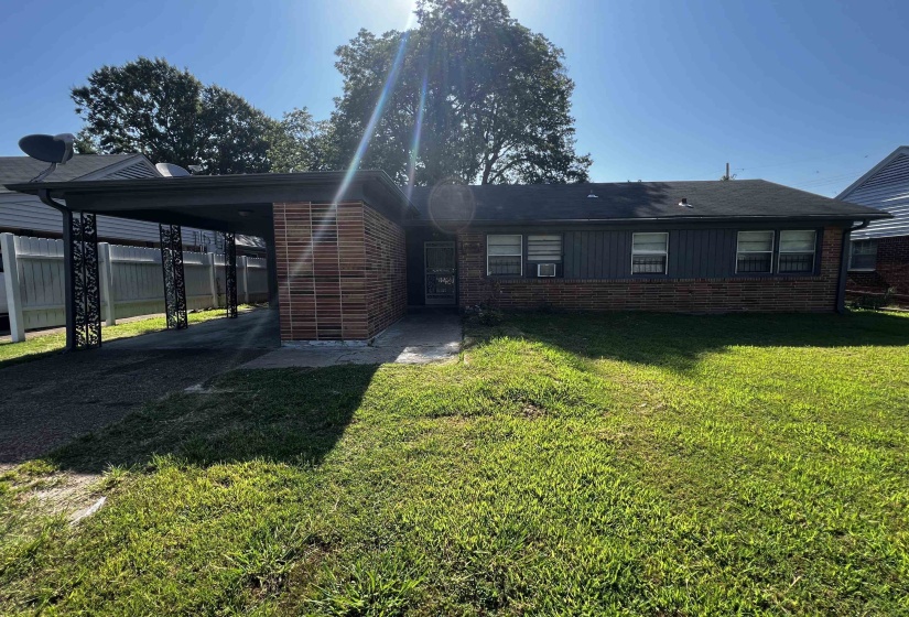 View of front of house with brick siding, an attached carport, and asphalt driveway