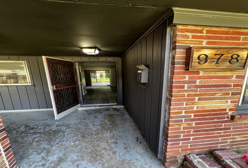 Doorway to property featuring brick siding