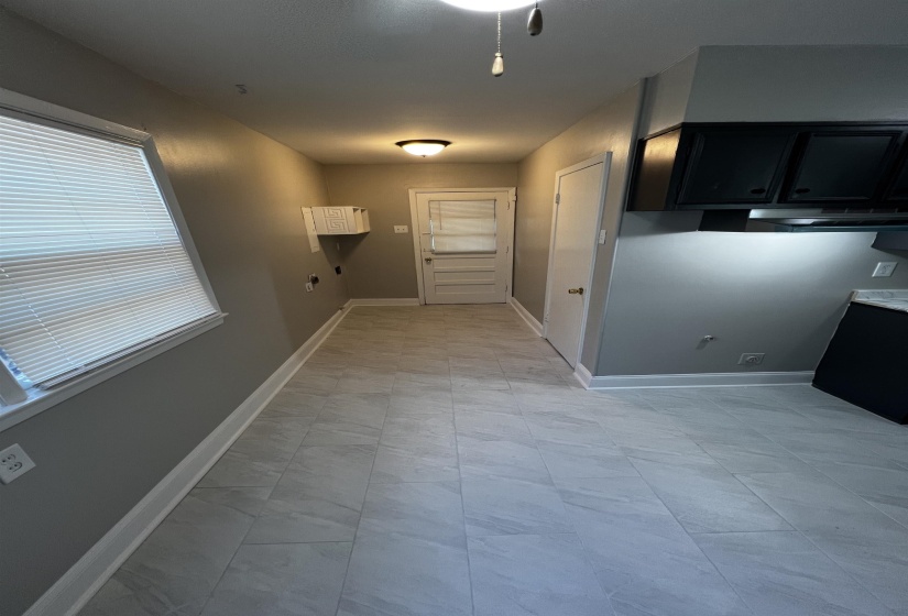 Kitchen featuring dark cabinets and baseboards
