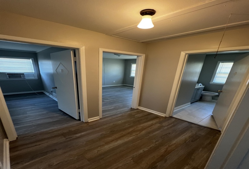 Corridor with attic access and dark wood-type flooring