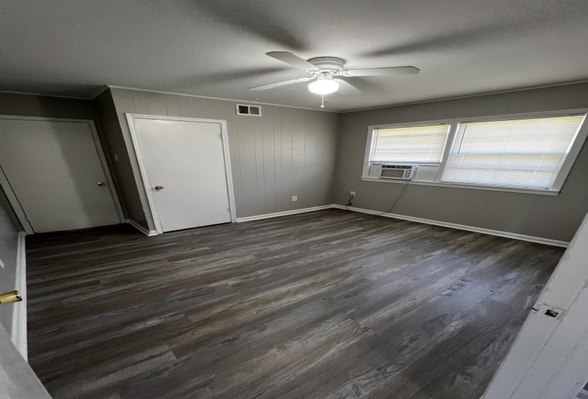 Unfurnished bedroom with dark wood finished floors, ceiling fan, and ornamental molding