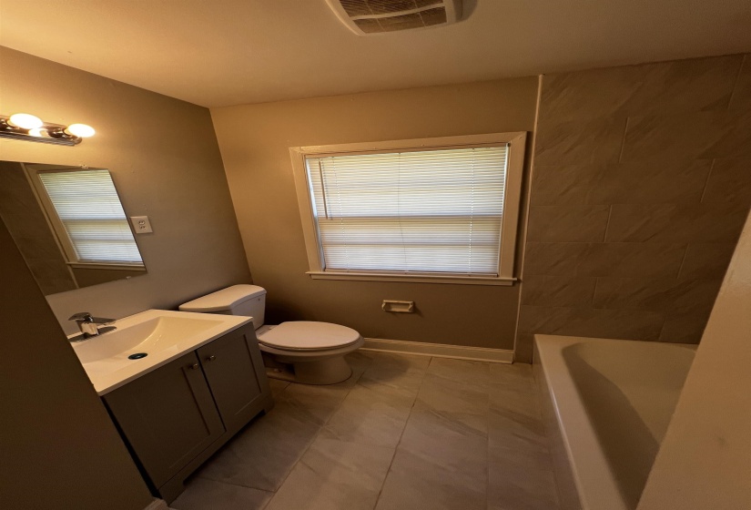 Bathroom with vanity, a tub, and tile patterned flooring
