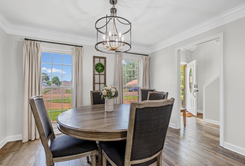 Dining space featuring wood-finish flooring, two large windows, and an ornate ceiling fixture
